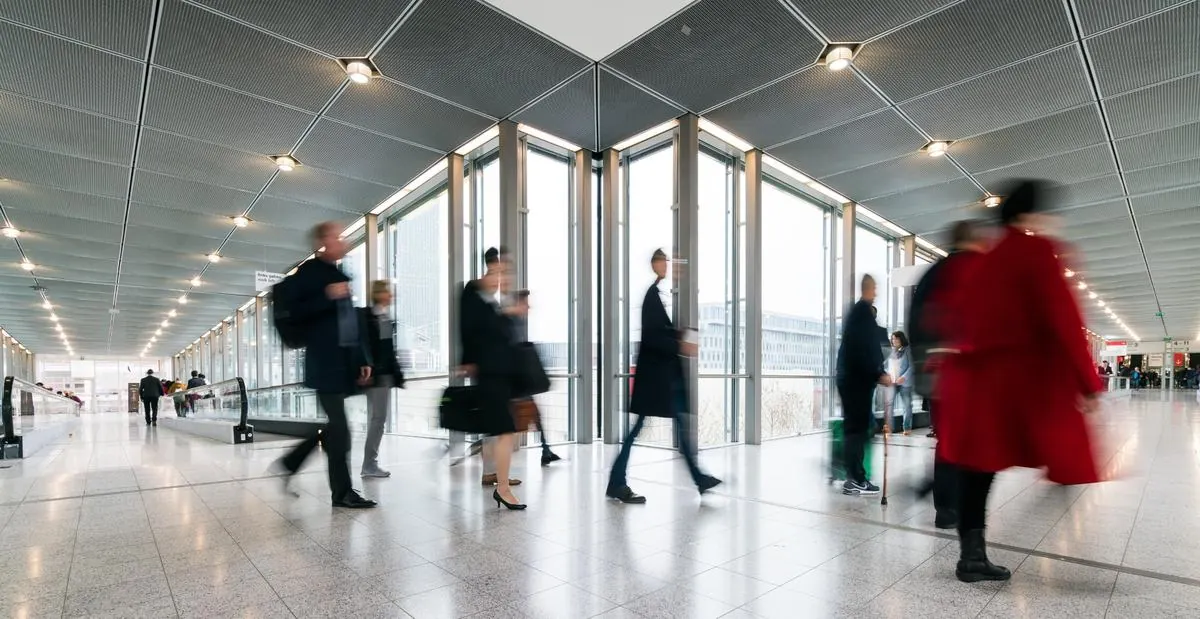 Viaggiatori in movimento nel corridoio di un terminal